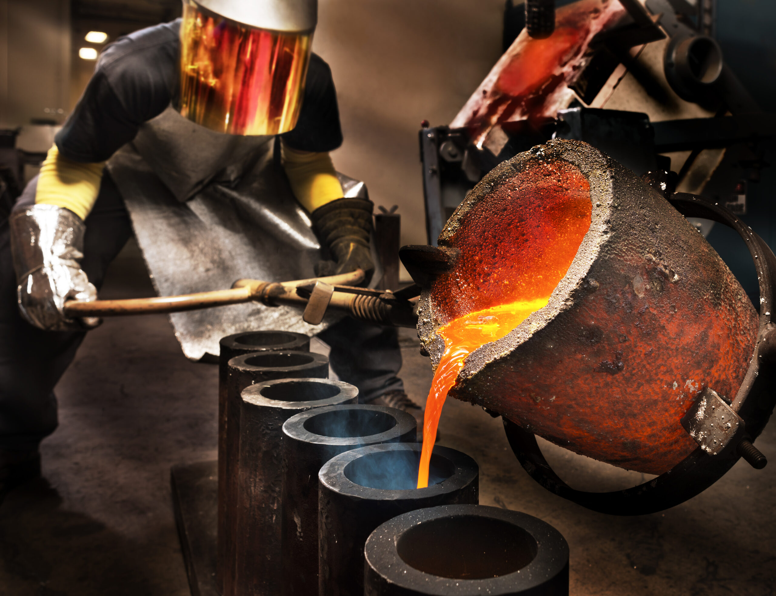 Worker pouring liquid metal into a crucible