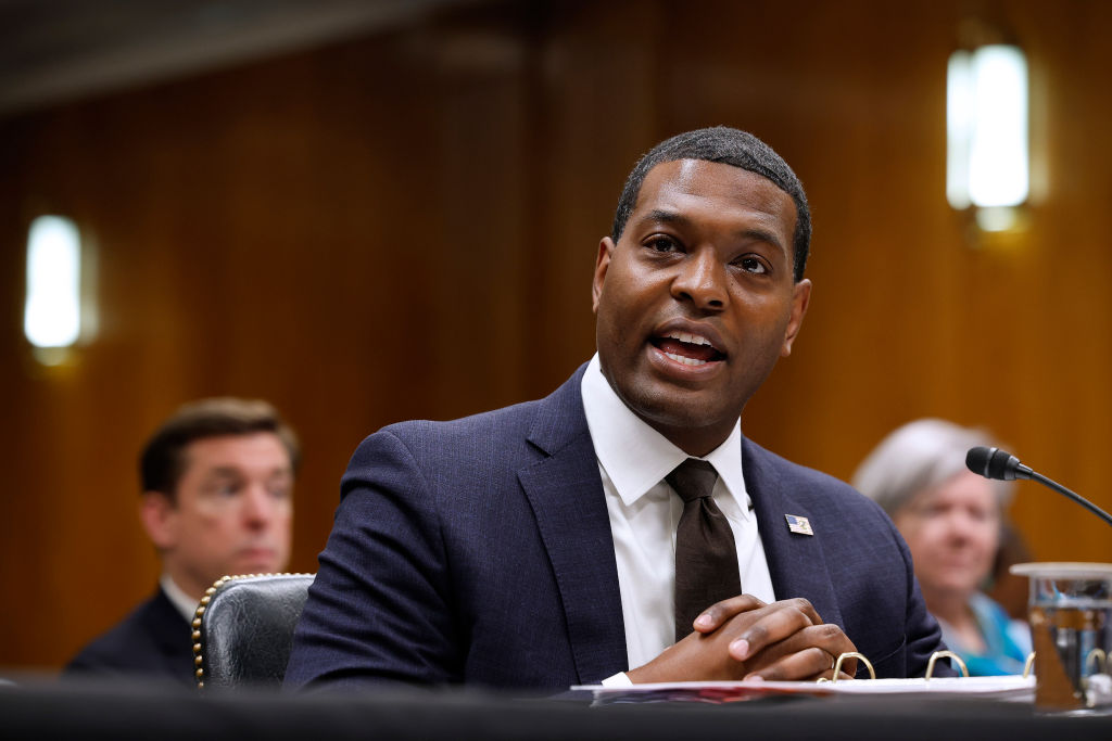 A man, Michael Regan, speaks in a wood paneled room (a Congressional hearing room).