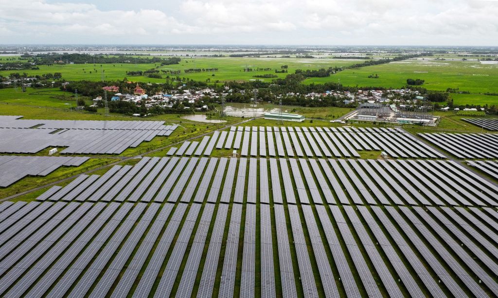 Aerial photo of a solar farm next to a small town and green fields.