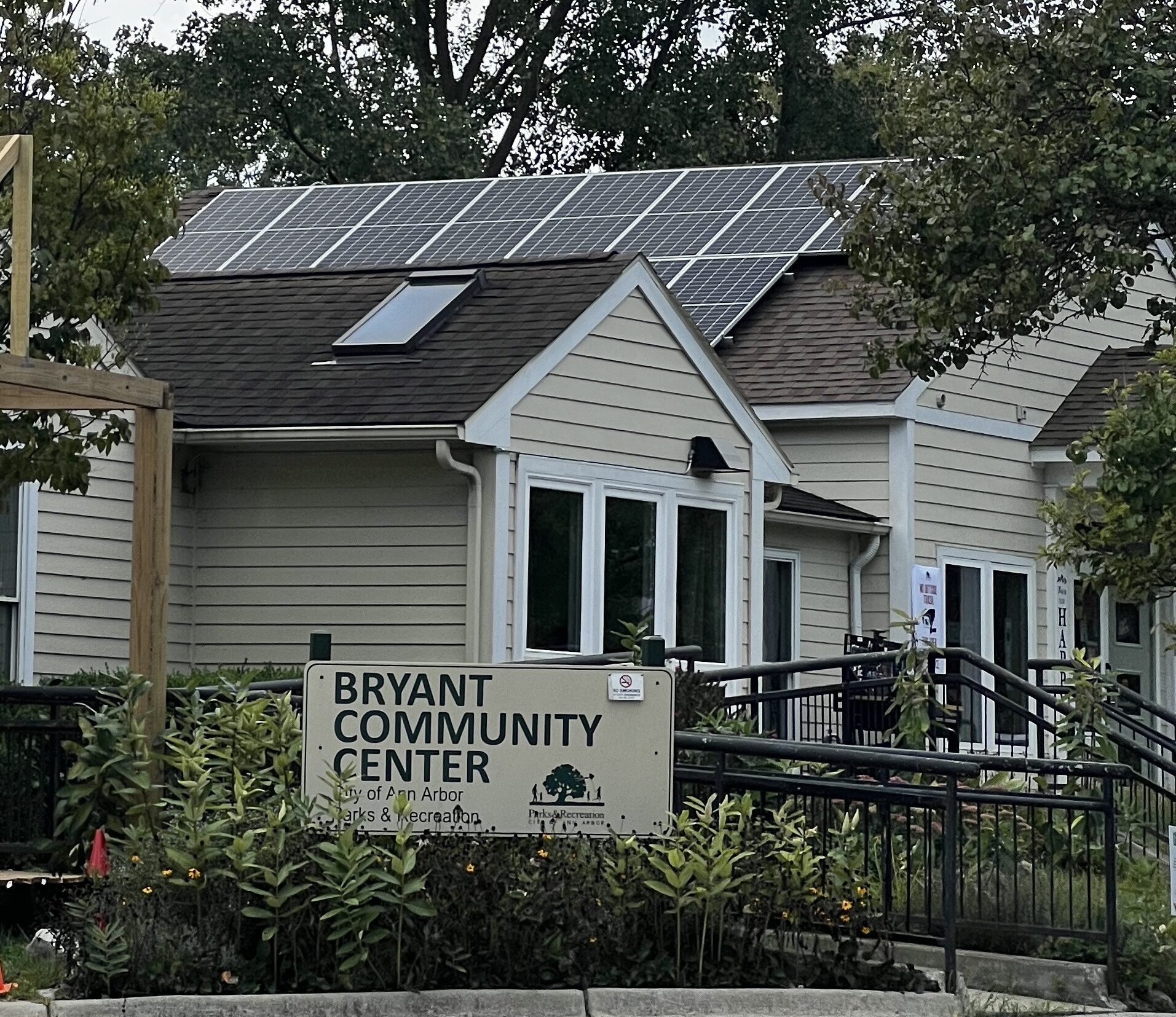 A yellow building with solar panels on the roof with a sign that reads "Bryant Community Center" out front.