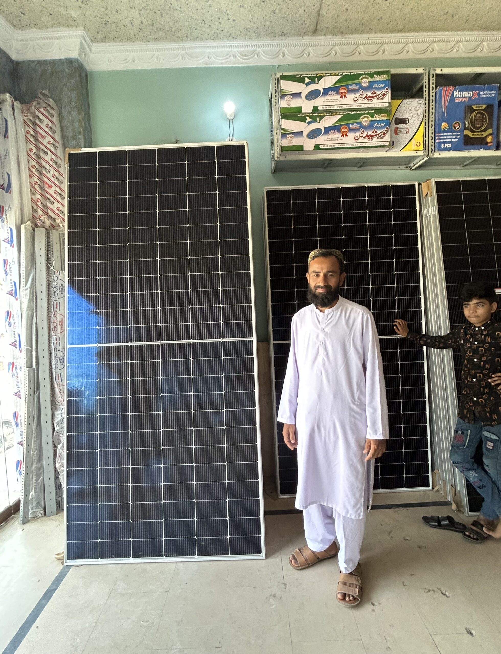 Near Karachi's bustling port, Eman Solar Energy salesman Ali Reza displays the stacks of solar panels that he says remain in high demand. Photo by Amena H. Saiyid