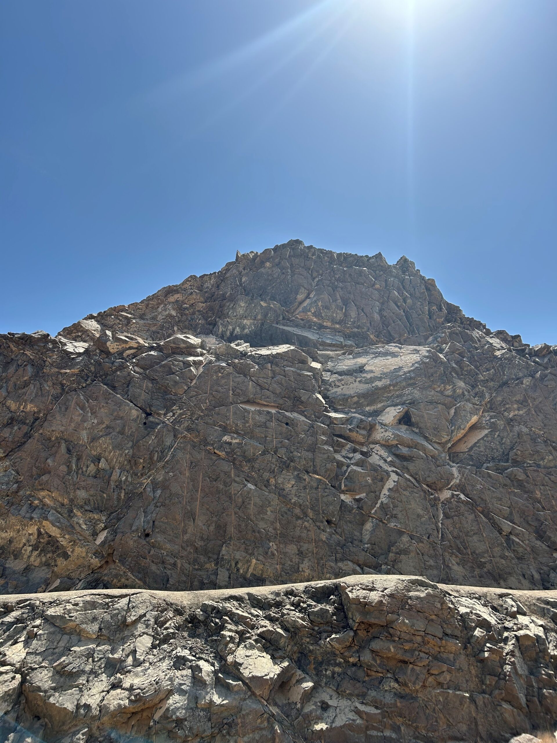 A closeup of the jagged outcrop shows natural fissures where white carbonates have deposited over millennia. Photo by Amena H. Saiyid, May 5, 2025.
